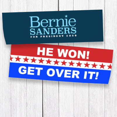 Politcal stickers laying on a white washed wooden table.