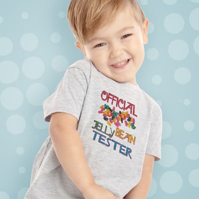 Cute young boy wearing a custom t-shirt with an Easter design showing Jelly Beans and stylized text that reads: Official Jelly Bean Tester.