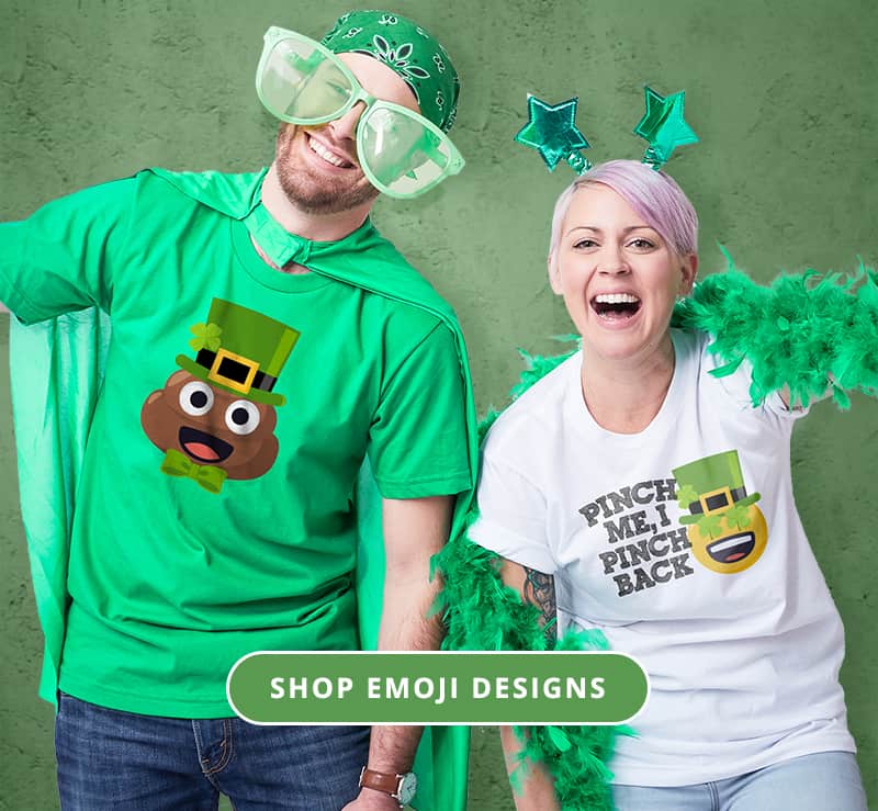 Couple wearing St Patricks day attire and custom t-shirts with Emoji (C) JoyPixel designs. The man's has the poop Emoji with a green top hat and the woman's whos a happy emoji with shamrock eyes, a leprechaun hat and stylized text that reads - Pinch me, I pinch back.