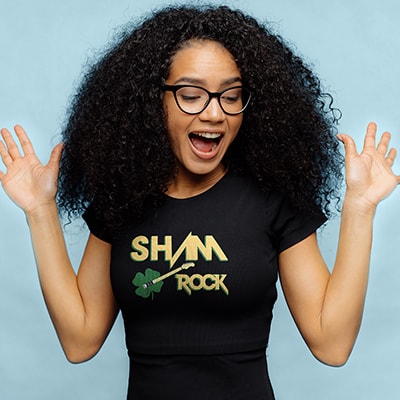 African American Female wearing a shirt with a funny design reading - Sham Rock with a guitar in the shape of a clover