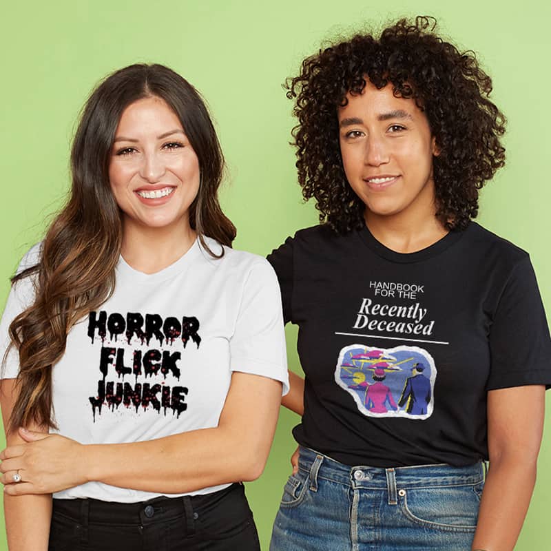 Two women wearing custom design t-shirts. One has a Beetlejuice design and the other has a Rocky Horror Picture Show design.