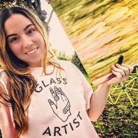 Female in light pink sweater with a custom Glass Artist design