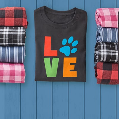 Black t-shirt and a variety of pajama pants choices. The T-Shirt has a custom text design that reads LOVE where the O is a paw print.