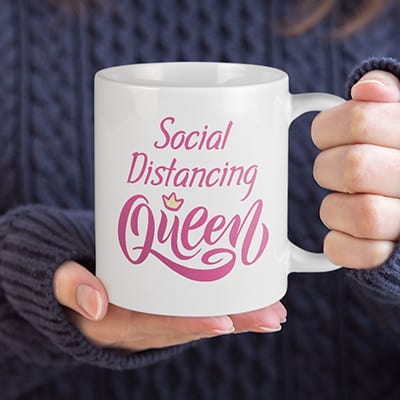 Woman holding a mug with stylized text custom design that reads: Social Distancing Queen.