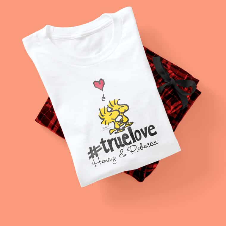 A pajama set showcasing an officially licensed PEANUTS(R) design with Woodstock(TM) and the hashtag True Love underneath.