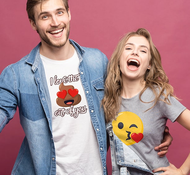 Couple wearing Emoji (C) JoyPixel designed shirts. The male's has the poop Emoji with heart eyes and reads - I love the Out of you. and the female's is just a big kiss face Emoji.