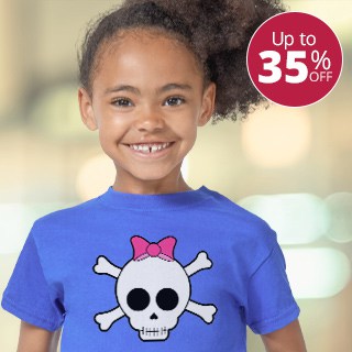Little girl wearing a blue kids t-shirt with a design showing a cartoon skull and crossbones with a pink bow
