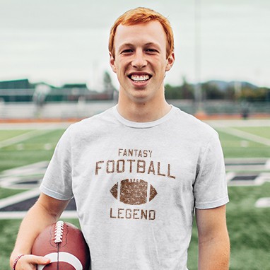 Young man holding a football wearing a custom design t-shirt with a football illustration and stylized text that reads: Fantasy Football Legend.