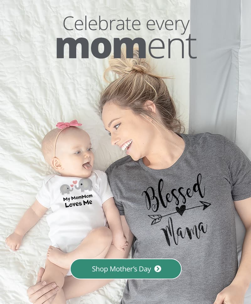 A mom laying in bed with her adorable little one wearing a shirt with a design that reads - Blessed Mama. The baby is wearing a bodysuit with a design reading - My MomMom Loves Me.
