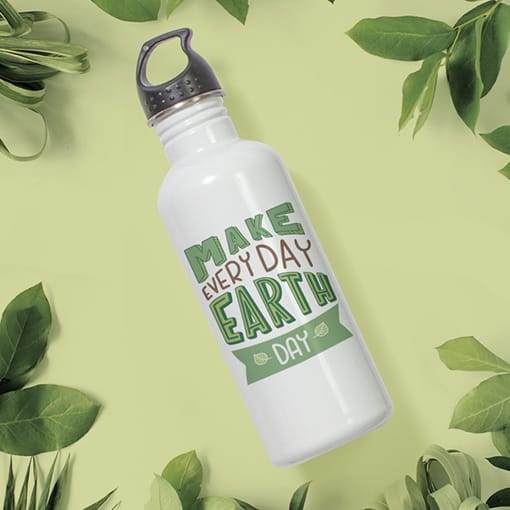 A stainless steel water bottle laying down with leaves around it and a design that reads - Make Everyday Earth Day.