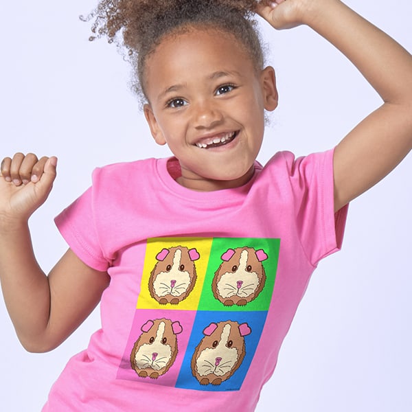 Adorable little girl wear a pink shirt with a four square design and illustrations of guinea pigs in each square.