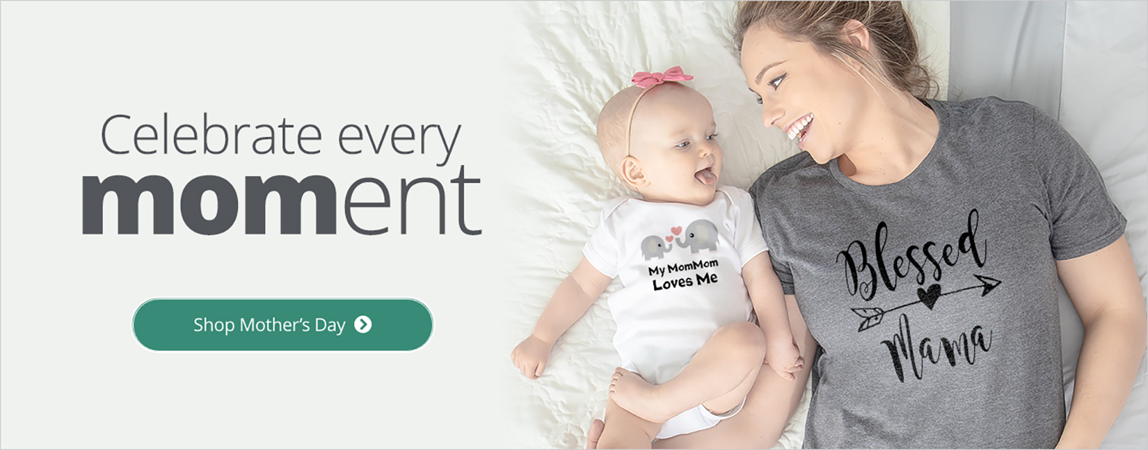 A mom laying in bed with her adorable little one wearing a shirt with a design that reads - Blessed Mama. The baby is wearing a bodysuit with a design reading - My MomMom Loves Me.