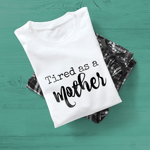 A white t-shirt black plaid bottom pajama set with a design on the shirt reading - Tired as a Mother.