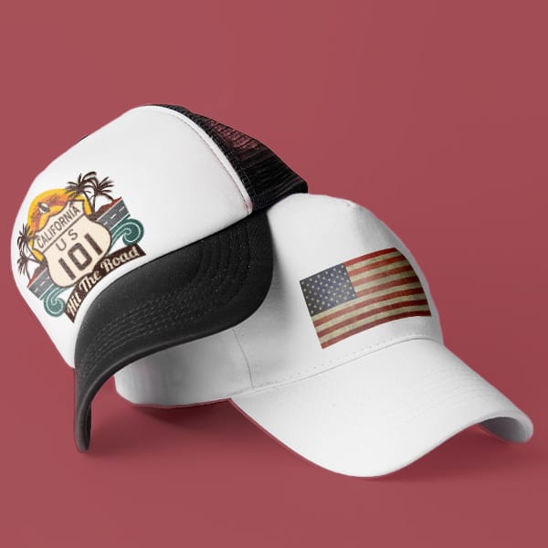 Two hats sitting on top of one another. The top hat has a classic design showing off the US 101 highway sign with some stylized imagery behind it. The bottom hat has a rustic American Flag design.