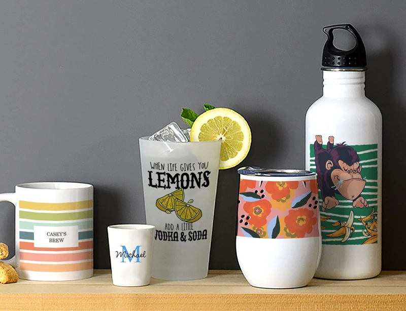 Multiple items from CafePress' extensive line of custom drinkware sitting on a wooden shelf displaying various designs found on site.