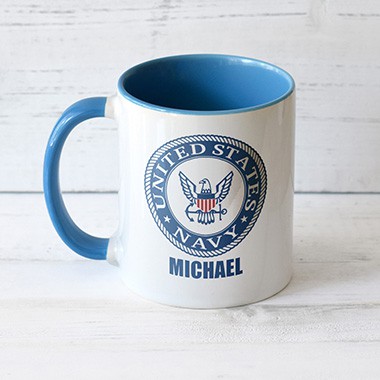 A personalized standard mug with a blue handle and blue insides showcasing the official licensed United States Navy logo along with the name of someone who serves, Michael.