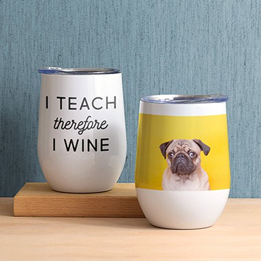 2 insulated wine tumblers sitting on a table. One has a text design that reads - I teach therefore I wine. The other has a photo of a pug sitting in front of a yellow wall.