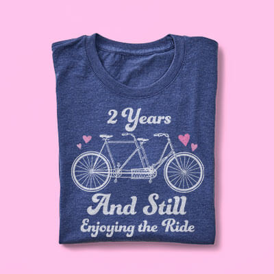 Personal Gift Ideas for Anniversaries. Image of a custom printed t-shirt with design that shows a bike and reads: 2 Years and Still Enjoying the Ride.