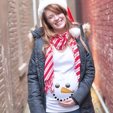 Pregnant woman wearing santa hat and custom printed maternity t-shirt with a snowman face design.